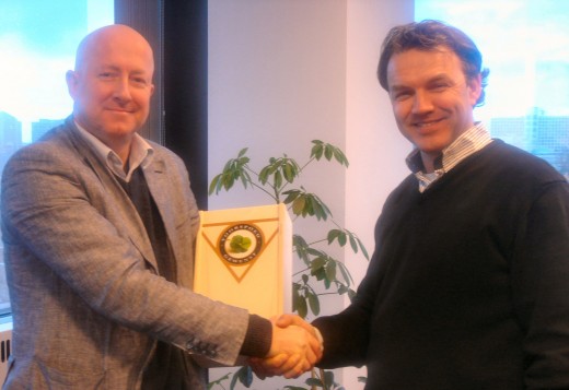 Gert van den Berg (rechts) van Breezz ontvangt felicitaties en een geschenk van Marc Gauw van de NL-ix.